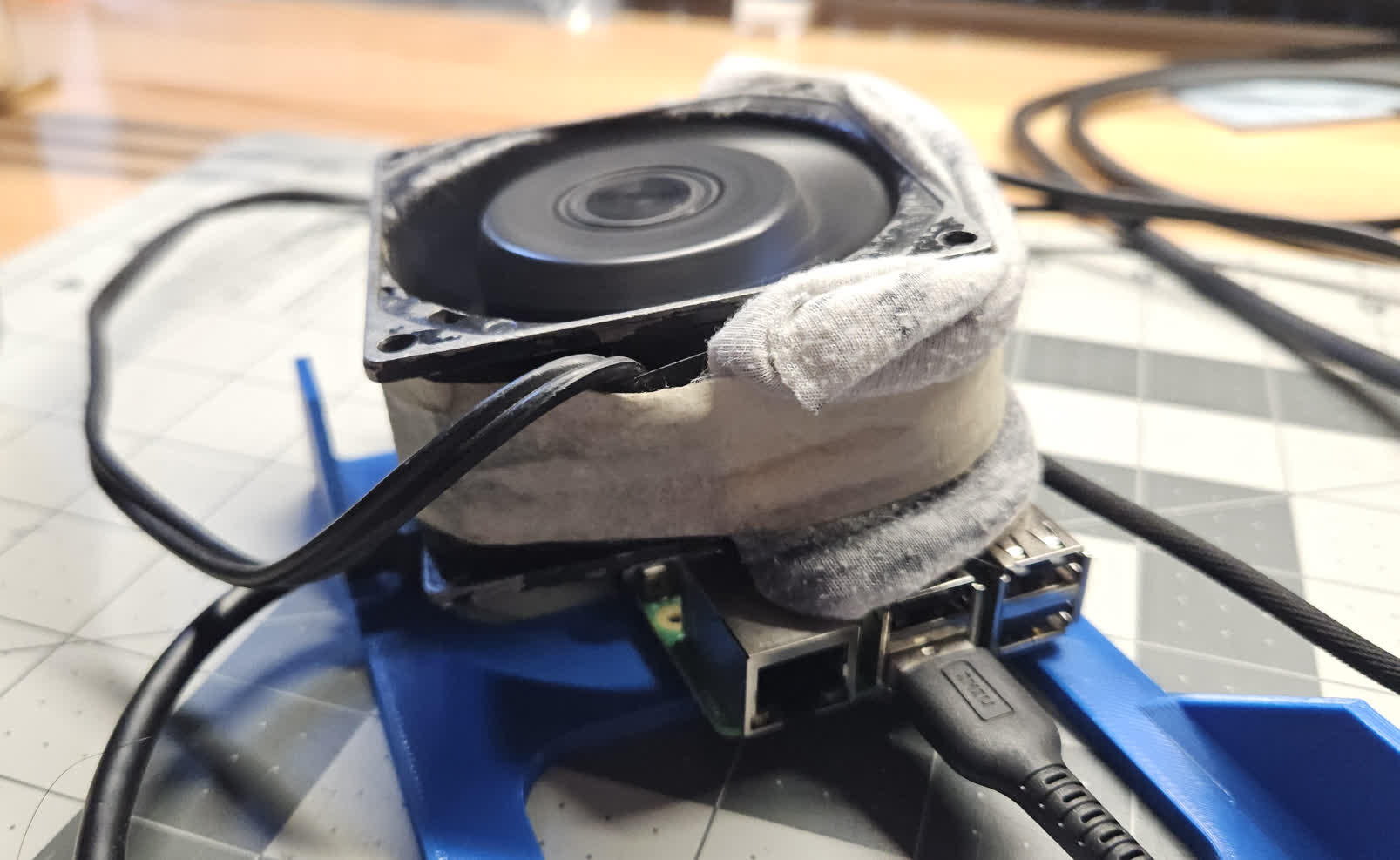 Picture of RPI sitting on workbench with a fan on it